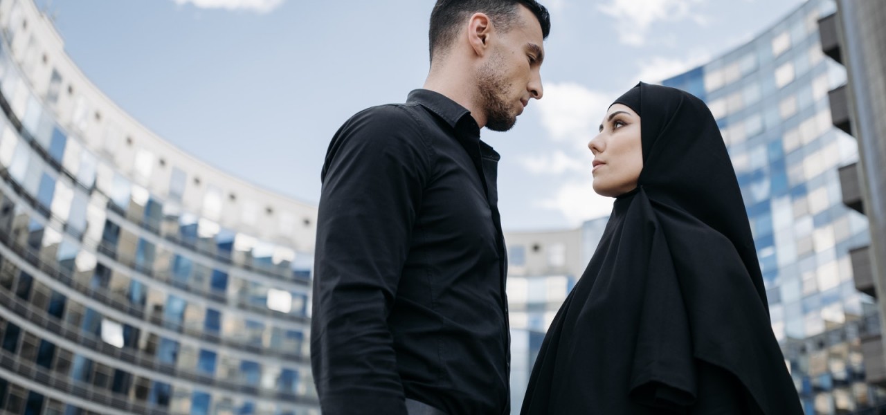A Man and Woman in Black Clothes Looking at Each Other