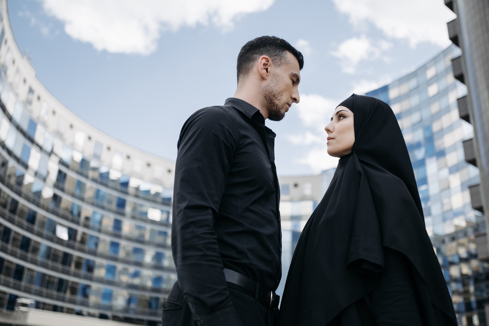 A Man and Woman in Black Clothes Looking at Each Other